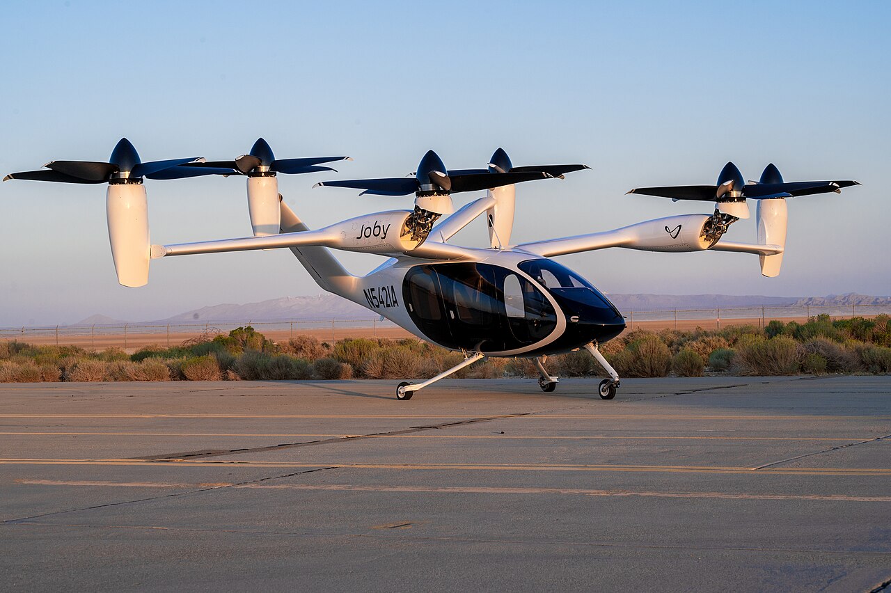 Joby Aviation S4 electric air taxi with its six tilting propellers, parked on a taxiway at Edwards Air Force Base, California, in 2023